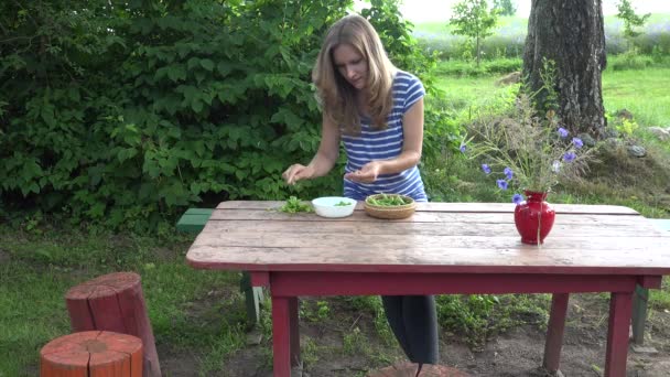 Wegetariańskie rolnik dziewczyna ręce łuski świeży zielony groszek na czerwony drewniany stół. 4k — Wideo stockowe