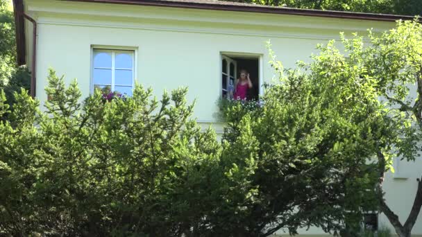 Ama de casa regar flor en maceta en su propia casa en verano. 4K — Vídeo de stock