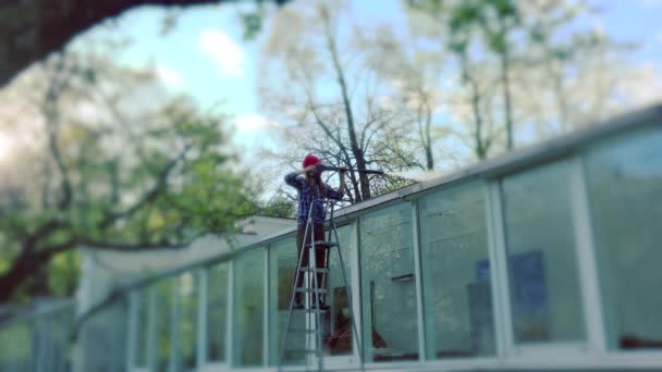 Chica trabajadora lavando casa de cristal con alta presión . — Vídeos de Stock