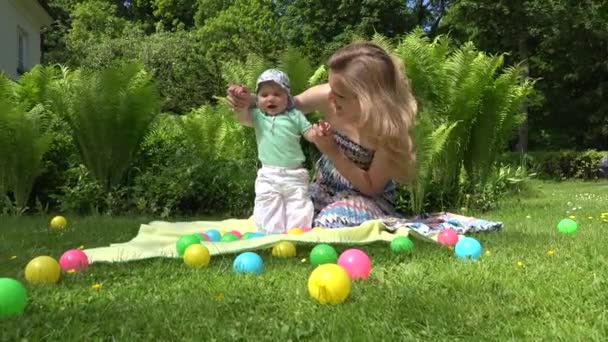 Fröhliche Mutter spielt mit Baby auf der Wiese. 4k — Stockvideo