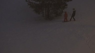 Küçük tepeden snowboard 'la kayıyor ve kar yağıyor. 4K