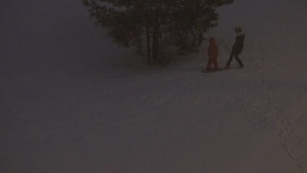 Anak skate dengan snowboard dari bukit kecil dan salju turun. 4K — Stok Video