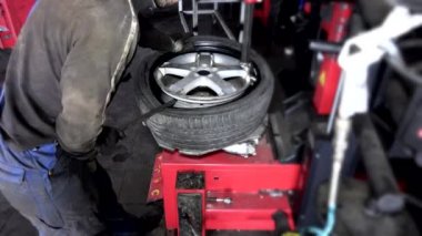 Tamir servisinde tekerlek lastiğiyle çalışan bir tamirci. 4K