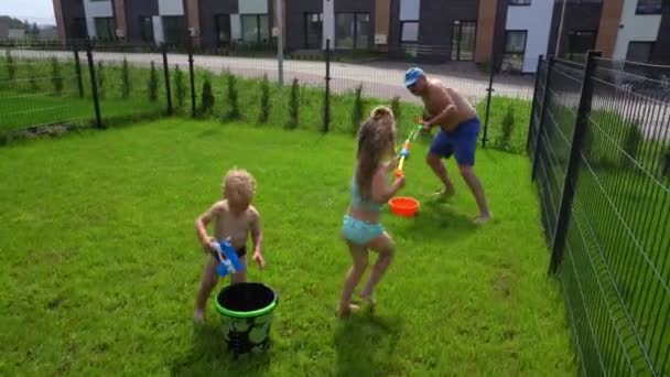 Смішний тато кидається на водну бійку зі своєю донькою. Щаслива грайлива сім'я — стокове відео