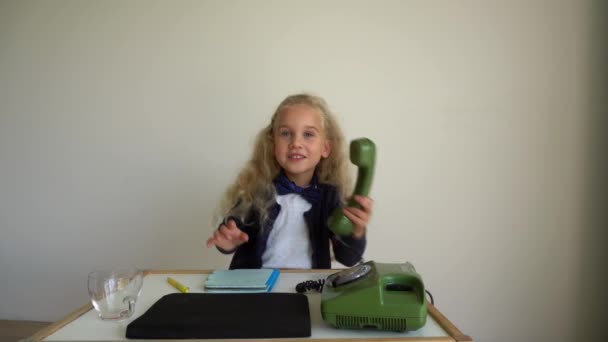 Счастливая девочка играет секретаршу с ретро-телефоном. Гимбальное движение — стоковое видео