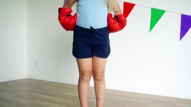 Angry blond girl with boxing gloves posing looking at camera. slow motion shot — Stok video