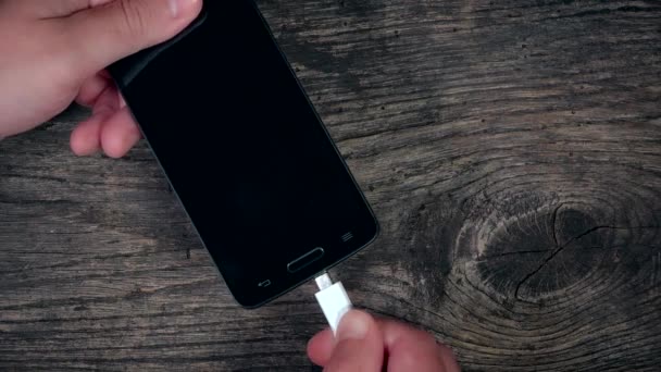 Man hand plug charger into two smart mobile phone. 4K — Stockvideo