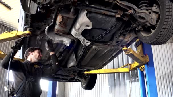 Man mechanic repair auto at car service repair station. 4K — Stockvideo