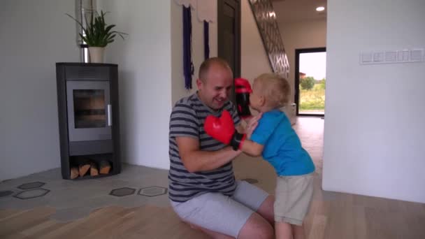 Pai amoroso e filho brincando em luvas de boxe juntos. Movimento de Gimbal — Vídeo de Stock