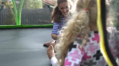 Kadın ve çocukları spor salonundaki trambolinde aktif olarak oynuyorlar.