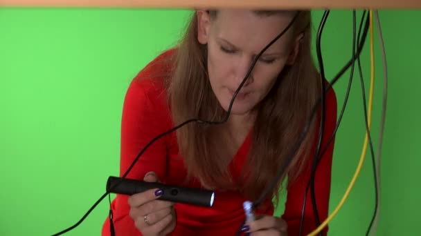 Frau unter dem Tisch versucht, das richtige Kabel für ihren Computer zu finden. 4K — Stockvideo