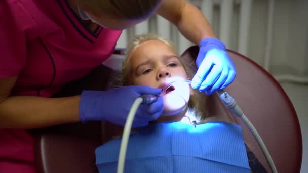 Леді стоматолог полірування маленьких дівчаток зубна емаль, захист порожнини рота — стокове відео