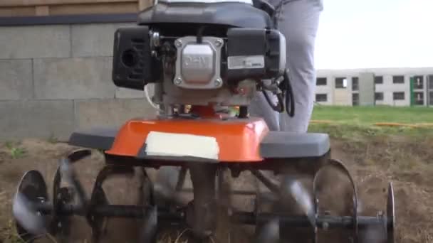 Worker plowing private apartment yard with cultivator. Gimbal movement shot — Stock Video