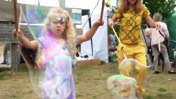 Matka a dcera foukání obrovské mýdlové bubliny s provazy — Stock video
