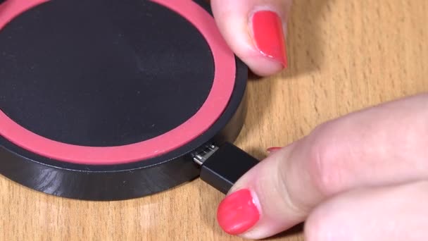 Meisje hand telefoon lader aan te sluiten op draadloze lader op tafel. 4K — Stockvideo