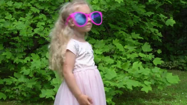 Speelse kinderen, jongen en meisje met een enorme zonnebril buiten. Gimbal motie — Stockvideo