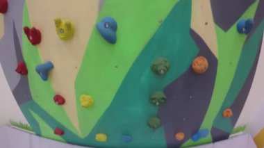 Oyun merkezindeki oyun parkındaki çocuklar için yapay kaya tırmanma duvarı. Gimbal atışı.