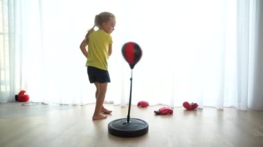 Fiziksel boşalma kavramı. Hiperaktif kız boks eldivenleriyle kum torbasına vurdu.