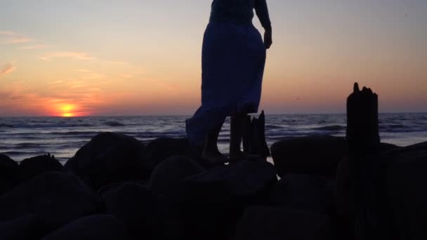 Romantyczna kobieta przechadzająca się po starych molo o zachodzie słońca. Sylwetka dziewczyny — Wideo stockowe
