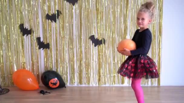 Preschooler girl decorating her room with pumpkins for Halloween evening — Stock Video