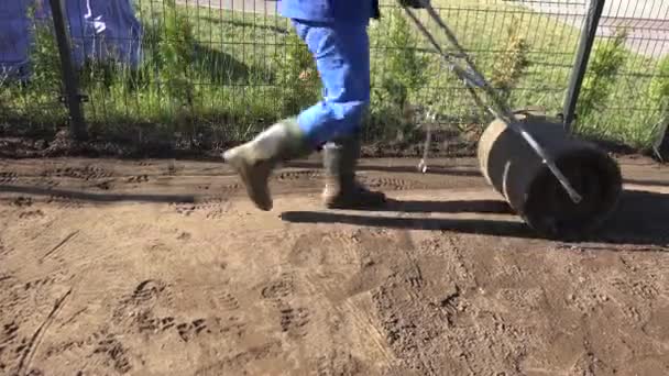 Man Compact Soil With Heavy Metal Roller. Handheld motion — Stock Video