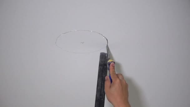 미 장판 천장에 손으로 톱으로 톱질하는 구멍을 내는 모습 — 비디오