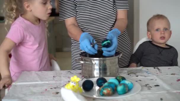 Mała córka i mały syn patrząc na mamę wziąć malowane pisanki — Wideo stockowe