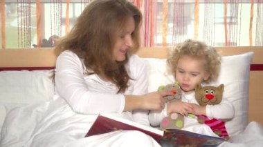 Anne yatak odasında kıvırcık kızına akşam masalını okudu. 4K