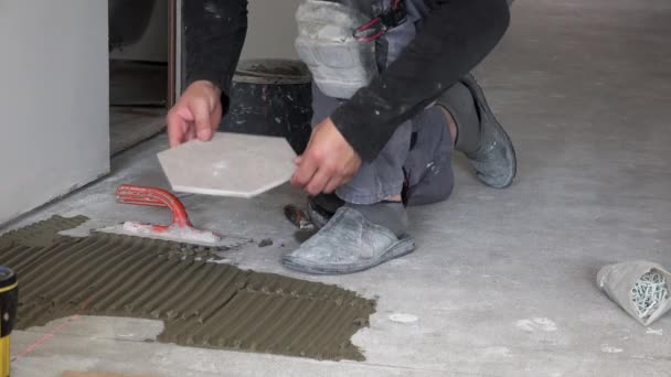 Ouvrier allumer le laser et poser des carreaux de plancher hexagonal — Video