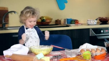 Kız aşçı un mutfağıyla oynuyor. Beyaz önlüklü kız. Mutfak arka planı. 4K