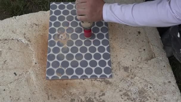 Professional worker man cutting holes in tile using an angle grinder — Stock Video