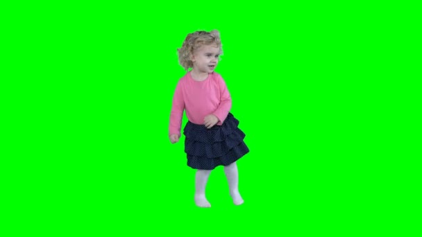 Liten flicka dansa och viftar med händerna på grön chroma nyckel skärmen. 4K — Stockvideo