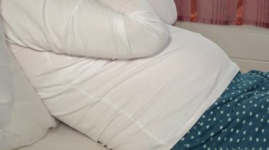 Depresyonda olan hamile bir manken. Ellerin altında yüzünü saklıyor. Negatif insan duyguları