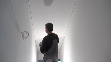 Boyacı zımpara kağıdıyla duvarları zımparalıyor. El kamerasıyla.