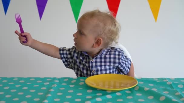 Niegrzeczny chłopiec wyrzuca marchewkę z talerza przy stole. Strzał w ruch Gimbala. — Wideo stockowe