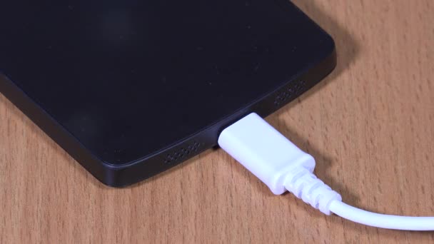 Fille main débranchez le chargeur du téléphone portable intelligent. 4K — Video