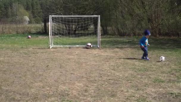 2 yaşındaki küçük çocuk futbol sahasında topla oynuyor. Gimbal hareketi — Stok video
