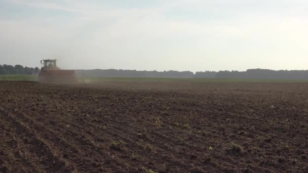 Çiftlik arazisindeki köylüler traktör ve ekin ekerler. 4k — Stok video