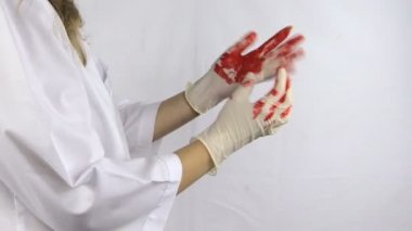 kadın cerrah doktor beyaz elbise içinde kanlı eldiven ellerini almak