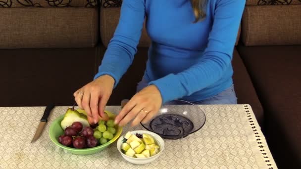 Mujer embarazada manos de niña poner frutas de uva en el plato — Vídeos de Stock