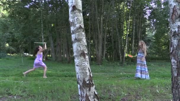 Pregnant woman with daughter girl play badminton game in park — Stock Video