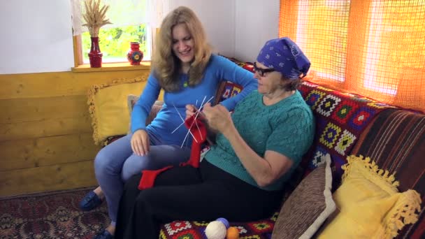 Abuela tejer calcetín hablar con la nieta embarazada en la habitación — Vídeo de stock