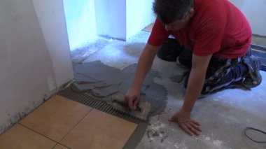 Tamirci el yapıştırıcı malzemesi yayılıyor. Seramik Karo lay