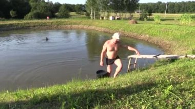 Bahçıvan adam su birikintisi kova ile çizmek ve tankın içine dökün