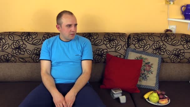 Kranker junger Mann misst Blutdruck an der Hand im Zimmer — Stockvideo