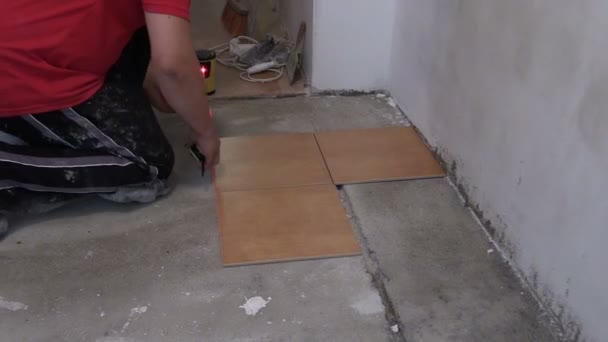 Cubo lleno de pegamento adhesivo y manitas hombre miden azulejos — Vídeos de Stock