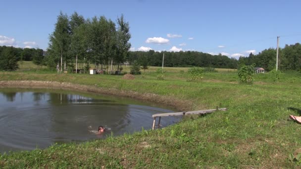 Těhotná matka zábal dívka s ručníkem z rybníka. zábava v létě — Stock video