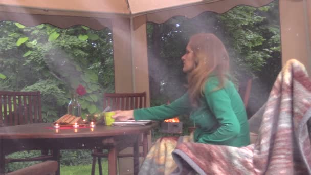 Žena dívka sedí u stolu s hořící svíčky a pít alkohol — Stock video
