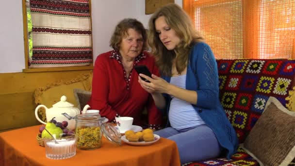 Ler gravid barnbarn Visa rörlig telefonerna till mormor — Stockvideo