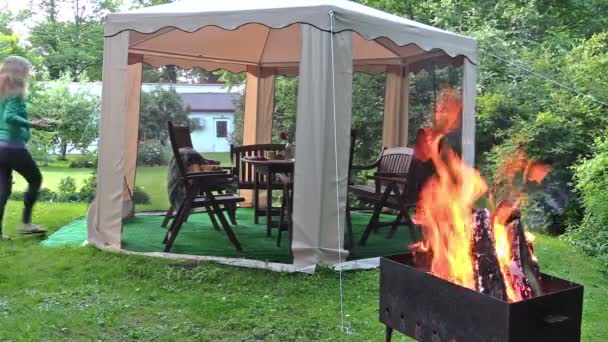 Chica preparar la mesa en la jaula al aire libre. Leña quemada en barbacoa — Vídeo de stock